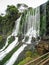 Wooden gazebo next to waterfalls with vegetation in Iguazu