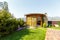 A wooden gazebo with a stone barbecue stove in the backyard of the cottage.  There is a green lawn around the gazebo.