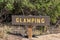 Wooden Glamping sign with yellow text on brown