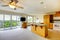 Wooden golden kitchen with dining room, TV and lots of windows to balcony.