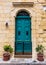 Wooden green door in a stone entry in Cospicua, Malta