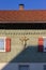 wooden green facade with crucifix and red color shutter of bavarian farmhouse