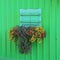 Wooden green painted boathouse facade, closed window with flower