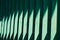 Wooden green slats. Bright abstract background. A beautiful streak of sunlight on a wooden fence. Element of finishing the facade