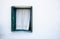 Wooden green window on a white wall