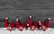 Wooden grey christmas background with red santa hats and gifts.