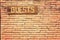 Wooden Guests sign on terracotta brick wall