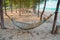 Wooden hammock with sand on beach.