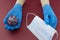 Wooden hands model wearing blue gloves and holding ball similar to coronavirus cells and mask