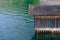 Wooden hangar on water, boathouse for boats and boats on stilts, surface of mountain lake Achensee in Austria, Alps mountains in