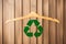 Wooden hanger with recycle symbol on wooden background. Recycling concept