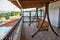 Wooden hanging bench for relaxation on the house balcony