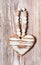 Wooden heart hanging on a rustic plank