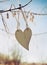 Wooden heart hanging on a tree branch against blue sky