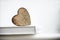 Wooden heart shape on a open book. Love reading concept close up.