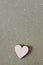 Wooden heart on a speckled green background