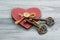 Wooden heart and two ancient keys on a natural wooden background