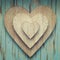 Wooden Hearts inside of each other on a turquoise vintage background