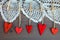 Wooden hearts on Ñlothespins on grey wooden background with lace.
