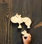 Wooden hippo toy in child`s hand nearby mosaic mother flat on table