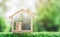 Wooden home with happy family of wooden doll is placed inside on nature bokeh. The saving money for house or real estate owner in