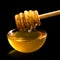 Wooden honey dipper over glass dish of honey. Black background.