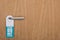 Wooden hotel room door with please do no disturb sign on handle