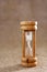 Wooden hourglass against a hessian background