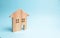 Wooden house on a blue background. The concept of affordable housing and mortgages to buy a house. Buying and selling apartments