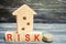 Wooden house and cubes with the word `risk`. The concept of risk, loss of real estate. Property insurance. Loans secured by home,