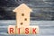 Wooden house and cubes with the word `risk`. The concept of risk, loss of real estate. Property insurance. Loans secured by home,