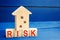 Wooden house and cubes with the word risk. The concept of risk, loss of real estate. Property insurance. Loans secured by home, ap