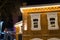 Wooden house decorated with Christmas glowing garlands at night. Festive decorations in the city, garlands and lights