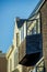 Wooden house exterior with bay window pod with visible glass and blue and white gradient sky with aged pannels or slats