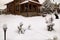 Wooden house exterior.Snowy cottage  backyard  with  snowbanks  and snowy pine trees.