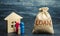 Wooden house with family and a bag with the word Loan. Buying a home in debt. Family investment in real estate and risk management