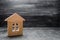 Wooden house on a gray concrete background. Concept of buying and selling housing, building a house. Rent of apartments. Realtors.