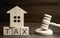 Wooden house with the inscription `Tax` and the judge`s hammer. Taxes on real estate, payment. Penalty, arrears. Register of taxpa