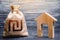 Wooden house and a israeli shekel money bag. Home purchase, investment in real estate construction. House project development.