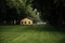 Wooden house on lawn in summer park, rainy day