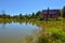 Wooden house made of beams and boards in a Russian village, field, pond