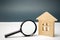 Wooden house and magnifying glass. Property valuation. Choice of location for the construction. House searching concept. Search