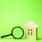 Wooden house and magnifying glass. Property valuation. Choice of location for the construction. House searching concept. Search