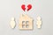 Wooden house and models of man and woman with red broken heart, divorce, end of relationship and  marriage concept