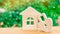 Wooden house and padlock in the shape of a heart on a green background. The concept of a love nest. Buying a house or apartment fo