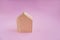 Wooden house on a pink background. The concept of peace, real estate purchase.