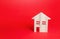 Wooden house on red background. Buying and selling real estate. Housing, realtor services. Renovation and home improvement