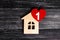 Wooden house with a red heart on a background of black wooden boards. A notification icon for the application. Love nest, love