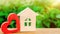 Wooden house and red heart. Concept of sweet home. Property insurance. A new home for family. Rent a house on Valentine`s Day.