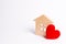 Wooden house with a red heart on a white background. Love nest, love relationships. Buying a house with a young family.